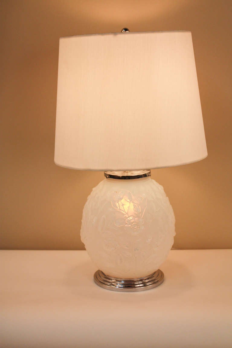 This table lamp features beautiful opaline glass with a nickel plate on bronze mounting. There is a light inside the base, as well a light for the shade. The opaline glass has a gorgeous floral pattern to it that is illuminated with the inside bulb,