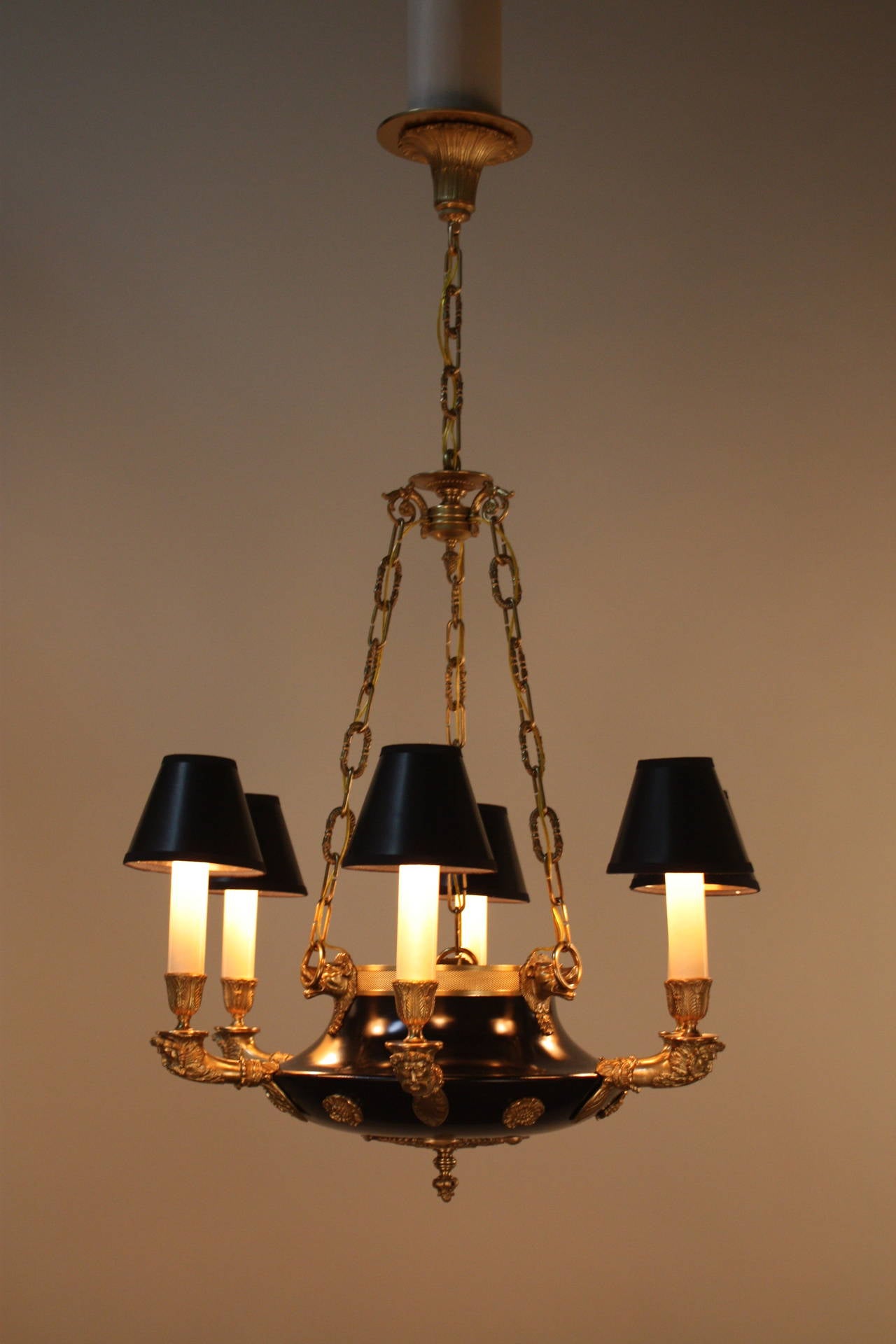 A fabulous six light Empire chandelier. Originally crafted in France during the early 20th century, this chandelier is made of beautiful bronze and black lacquer. A truly timeless piece, this hand crafted fixture is filled top to bottom with ornate