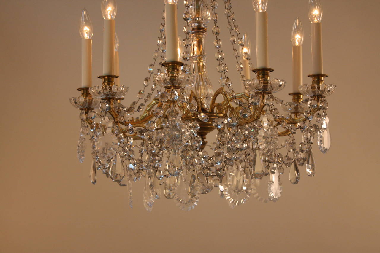 Crafted in 19th century France, this fantastic crystal and bronze chandelier features nine stunning lights, making for a bright and beautiful piece.