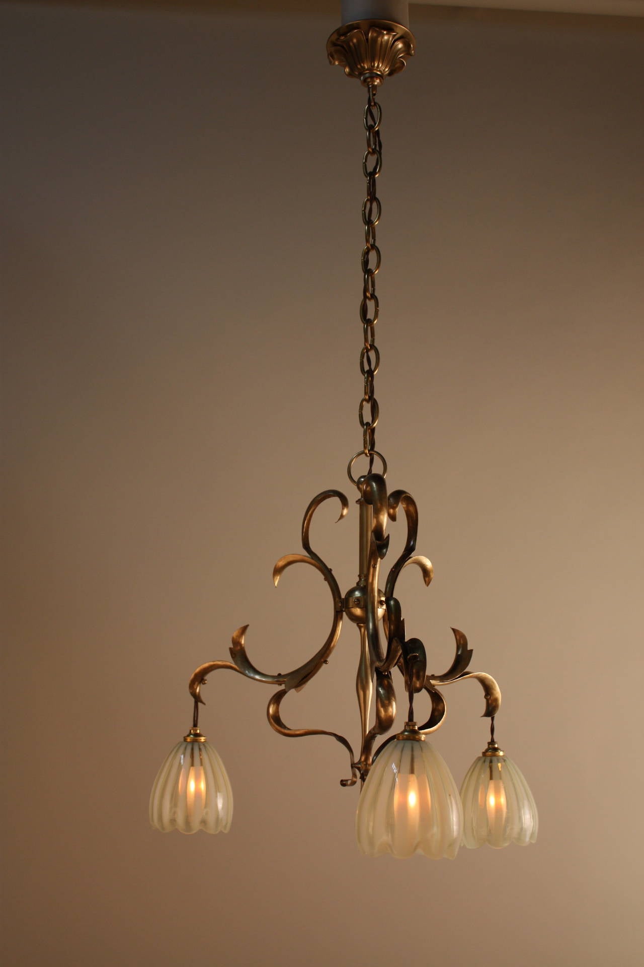 Fantastic brass Art Nouveau chandelier with three beautiful opalescent glass shades.