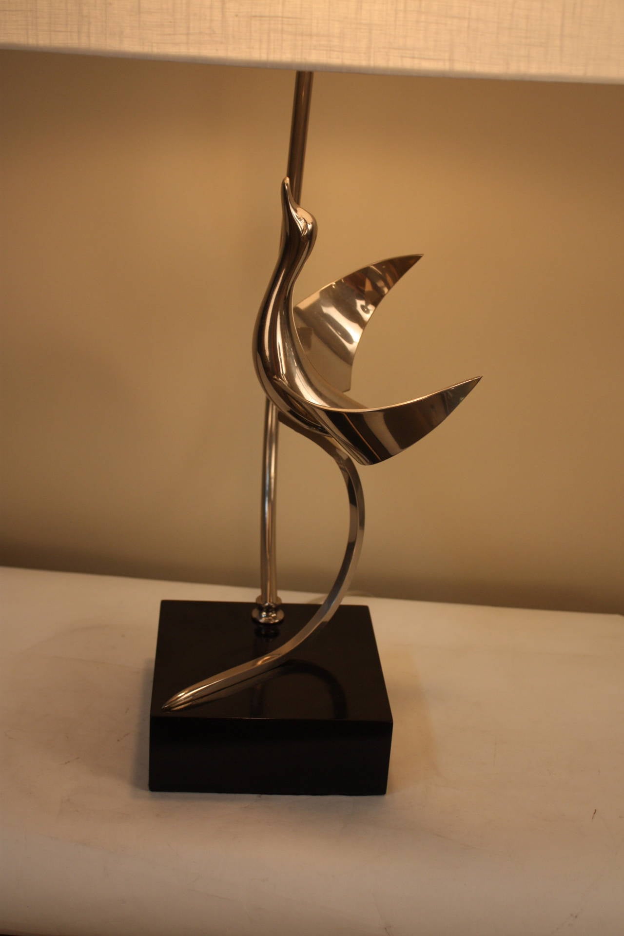Lancia vintage flying bird nickel on bronze table lamp, Italian, 1960s. Modern bird sculptural beautifully flies against a black lacquered wooden base.