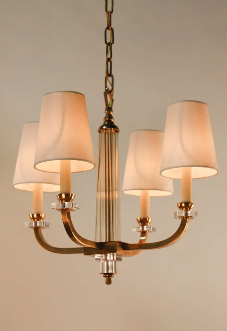 A simple but elegant four arm bronze and crystal chandelier by modernist designer Jacques Adnet.