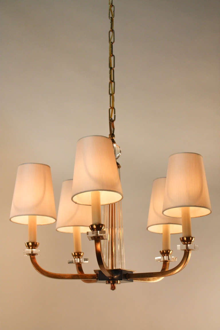 A simple but elegant five arm bronze and crystal chandelier by modernist designer Jacques Adnet.