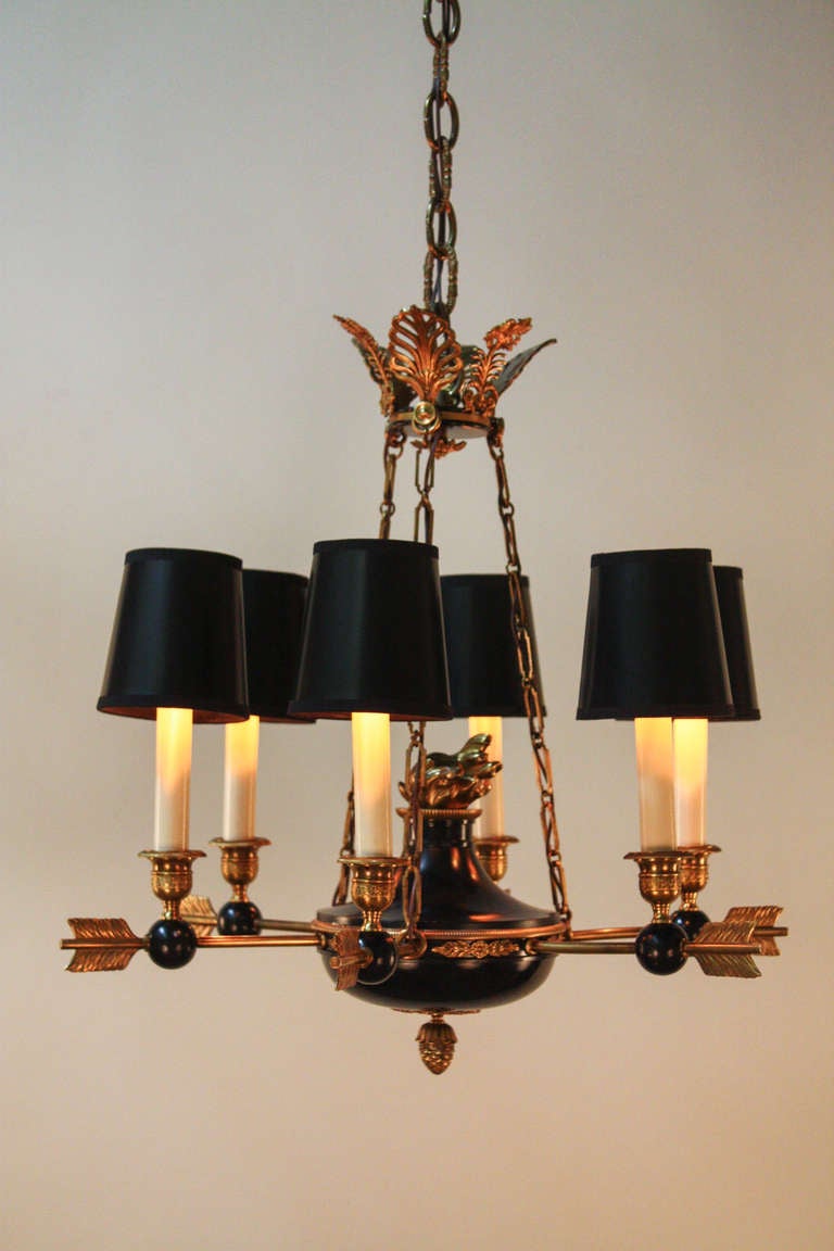 This beautiful French Empire chandelier is made of bronze and black lacquer. Featuring six lights, each arm has the design of the end of an arrow pointing towards the center of this fantastic chandelier.

The diameter is 21