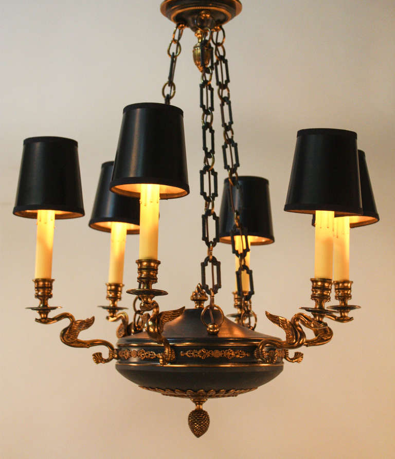 Made in France during the 1930s, this gorgeous six light chandelier is made in the classic Empire style. Traditional bronze, filled with incredible detail work, adorns the dark green lacquer body. This chandelier measures 23