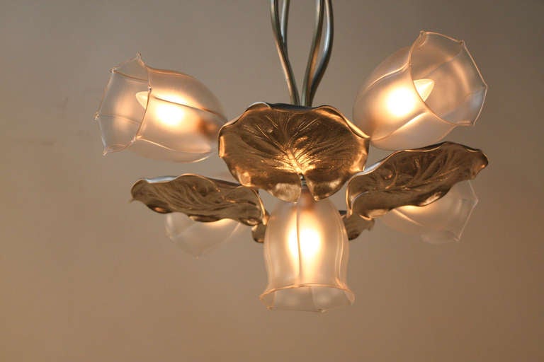 This French Art Nouveau chandelier is made of beautiful nickel on bronze and glass. 

Four large nickel on bronze leaves hang from the center, and five tulip shaped glass shades extend outwards, creating a naturally inspired design.

This