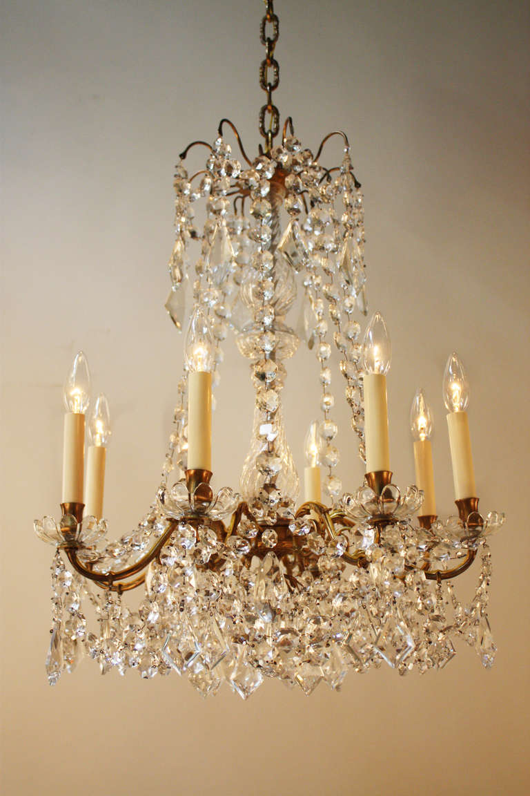 Made in France during the late 1800s, this stunning chandelier is adorned with dozens of ornate crystals and elegant bronze. The chandelier features eight lights which beautifully illuminate the dangling crystals with a classic elegance.

The