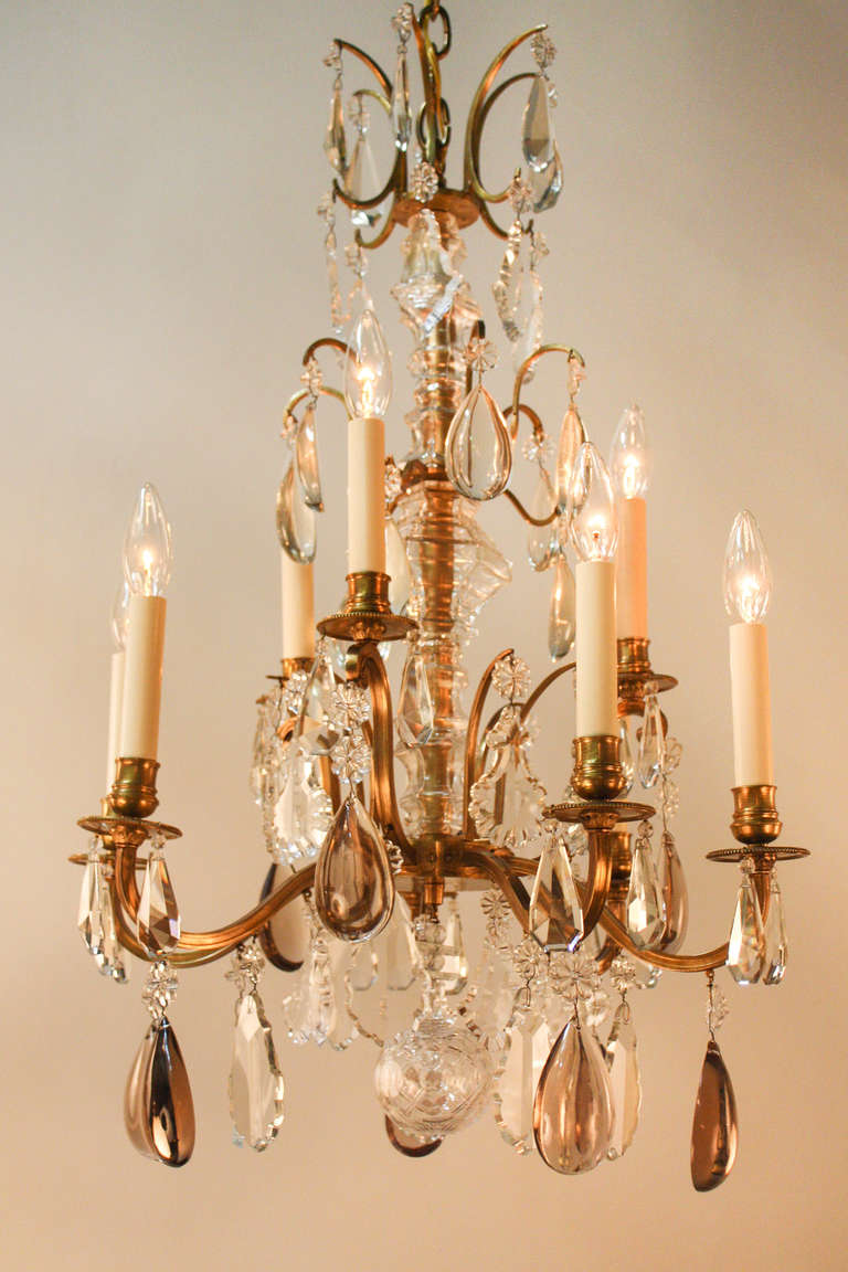 Made of gorgeous French crystal and bronze, this nine-light chandelier was fashioned in the 1930s.

This hand-polished chandelier is adorned with a variety of elegant crystals, ranging from clear, to pearl, to amber in color: perfectly