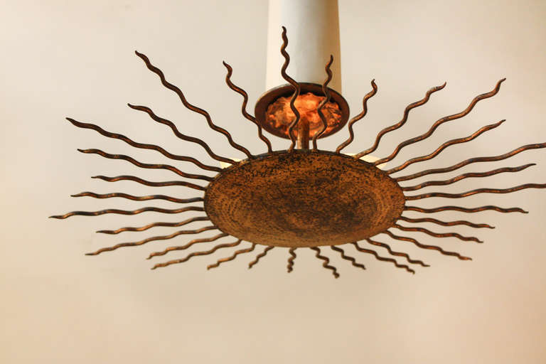 This beautiful flush mount light is made of gold leaf on hand made iron. It is fashioned in shape of the sun with four lights for maximum brilliance. The diameter is 25