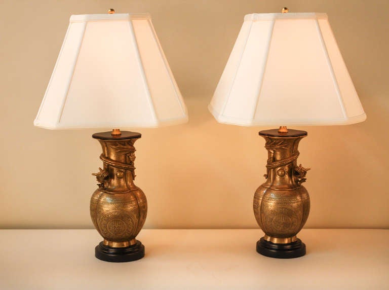 These beautiful Chinese table lamps were originally bronze vases that have been professionally converted to lamps. 

The dragon, which symbolizes strength and good luck, wraps around the neck of the lamp. The symbol in the center means 