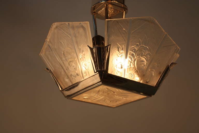 A fantastic Art Deco fixture. This flush mounted chandelier features five ornately decorated glass panels and a classic nickel on bronze body.