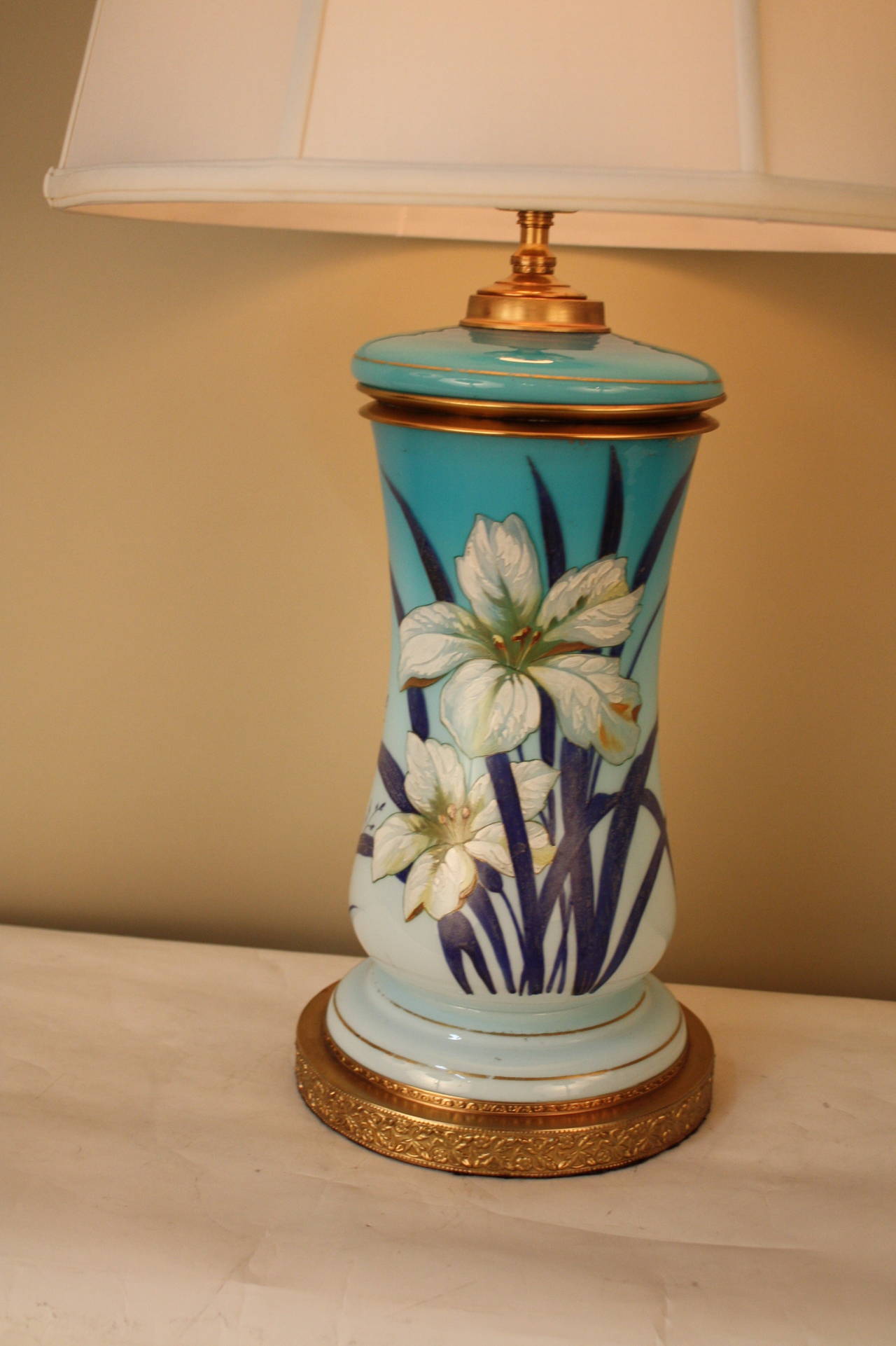Charming electrified oil lamp in light blue French opaline glass featuring hand-painted lilies.