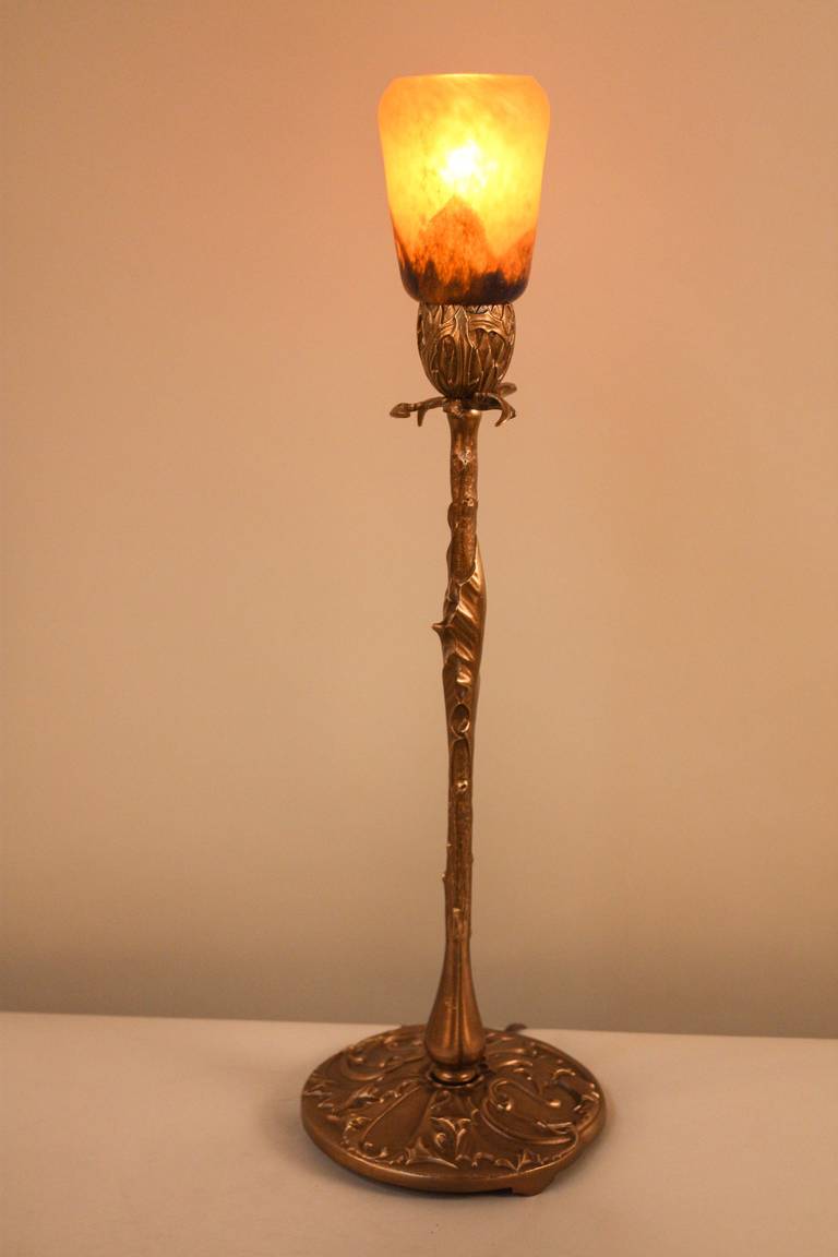 A wonderful Art Nouveau lamp with a unique bronze flower stem design. A beautiful glass shade serves as the 