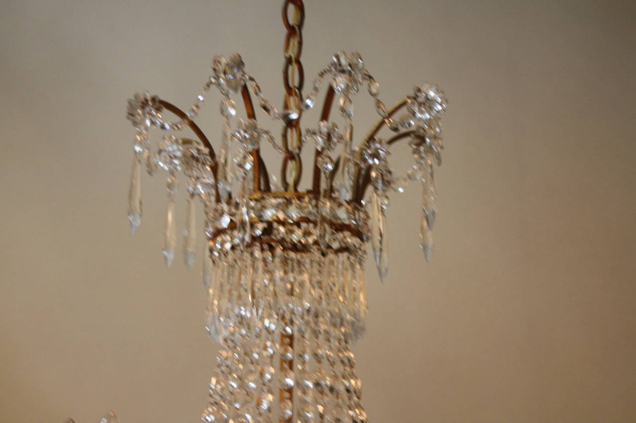 Wonderful handcrafted gilded iron twelve-light French crystal chandelier by Bagues.