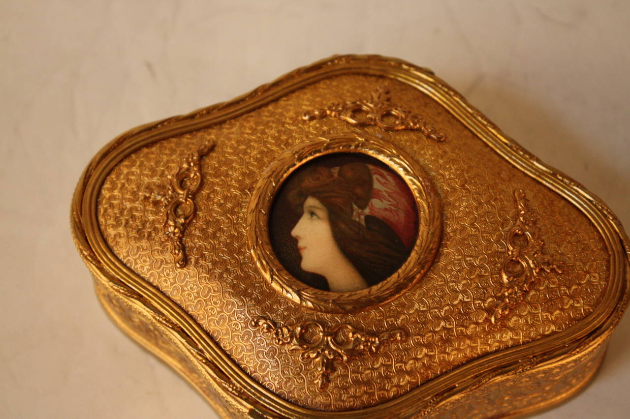 An elegant late 19th century French Art Nouveau gilt- bronze Jewelry box with center  of a hand painted enamel on copper of a beautiful woman.