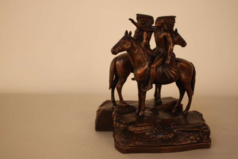 A beautiful pair of bronze bookends of two Native Americans sitting on horse back. These stunning sculptures can be used as bookends or displayed as statues.