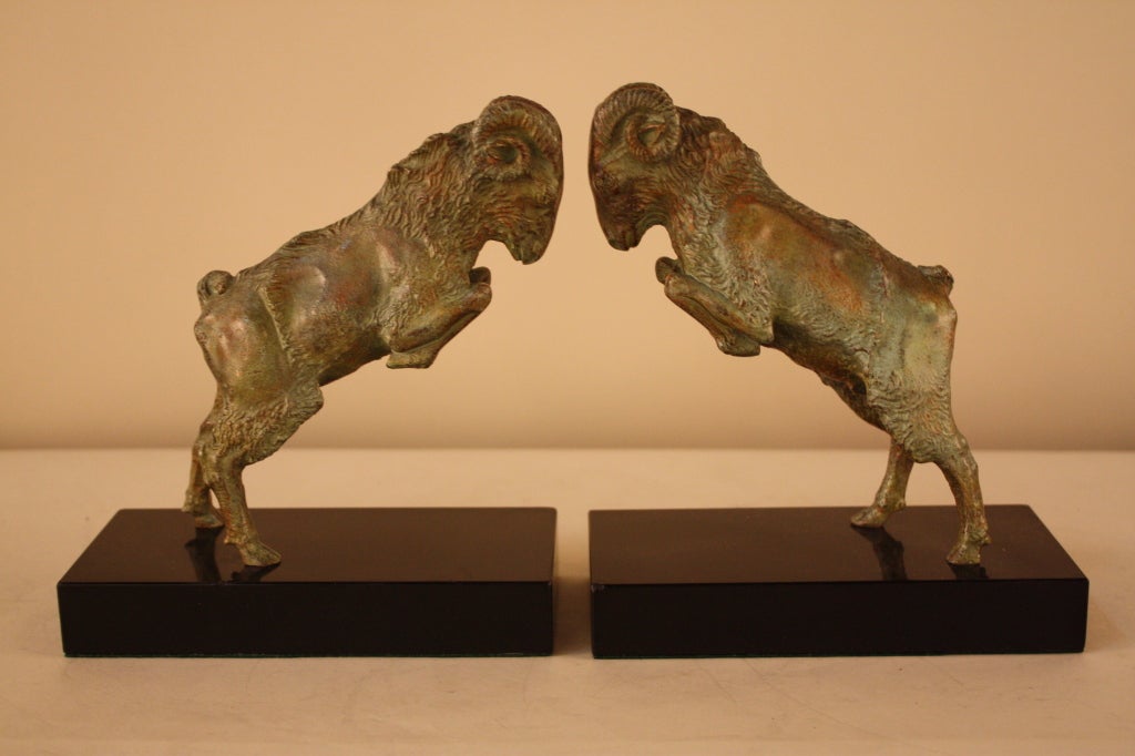 A beautifully sculpted pair of bronze bookends. These butting rams have a gorgeous green and brown patina, and are mounted on black marble. Note picture three for a detail in the black marble.