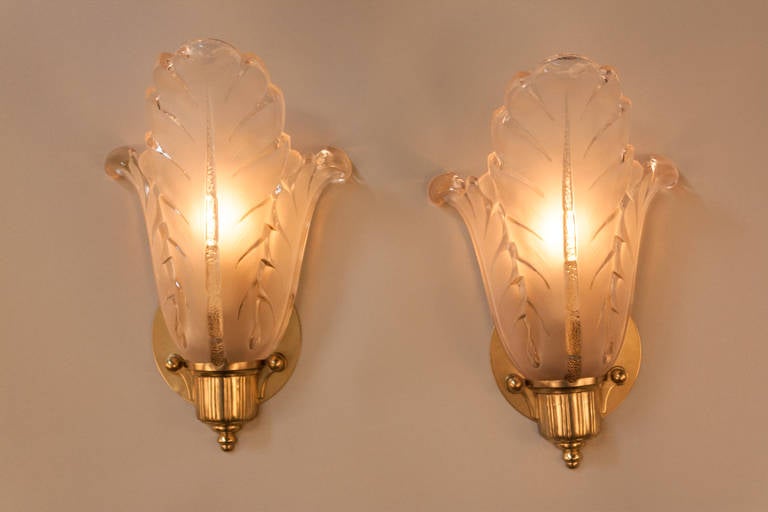 A fantastic pair of frost and clear glass wall sconces with nickel on bronze hardware by Ezan.