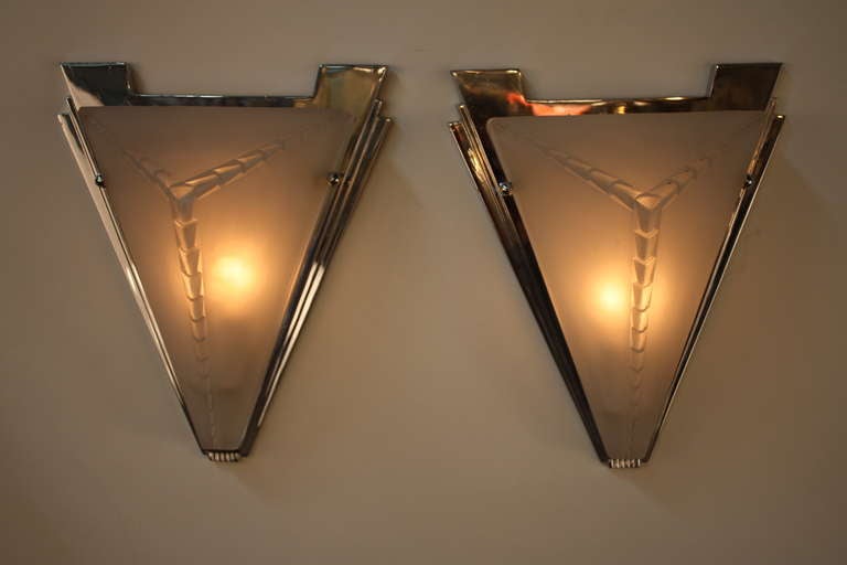 A simple but elegant pair of Art Deco wall sconces. With triangular glass faces and chrome, these sconces are a beautiful embodyment of modernist Art Deco design.