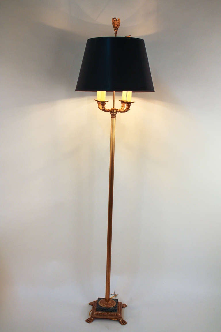 An elegant Empire-style bronze floor lamp with four lights. Made in France during the 1930's, this piece features a beautiful green marble base. A bronze eagle finial sits atop the lamp.