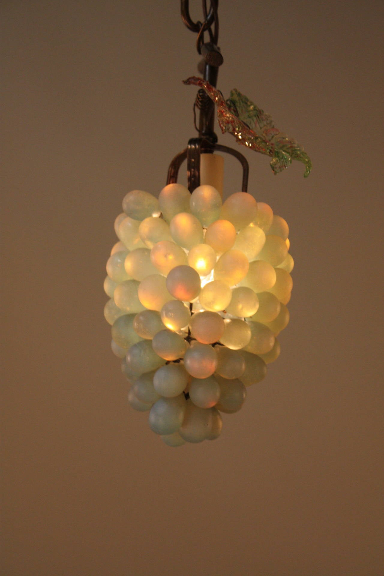 Yellow or green grapes growing on vine in bright sunshine, that is what this artist tries to create by grouping blown grape shaped opaline glass that hang from bronze hardware with light in the center. (Single 60 watt light).