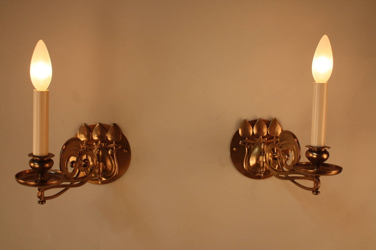 These beautiful Art Nouveau wall sconces are made of Classic bronze. The arms are easily adjustable for maximum convenience. 
 These sconces have been professionally restored and are designed to be wall-mounted. Originally built to hold candles,