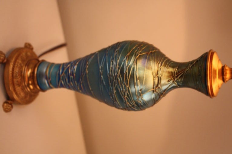 A beautiful threaded blue iridescent art glass lamp made by the famed Durand art glass company. This piece features a base with bronze mounting.