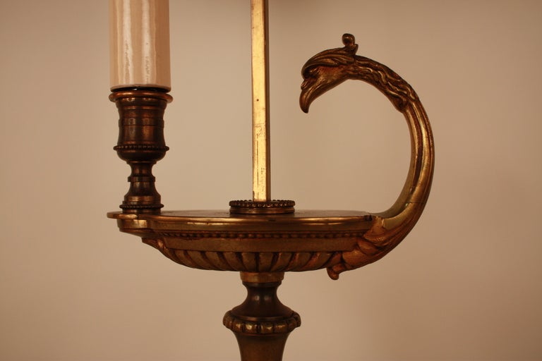 This wonderfully designed single light desk lamp was crafted in France. Made of bronze, this lamp features a gold floral design over the adjustable metal lampshade.