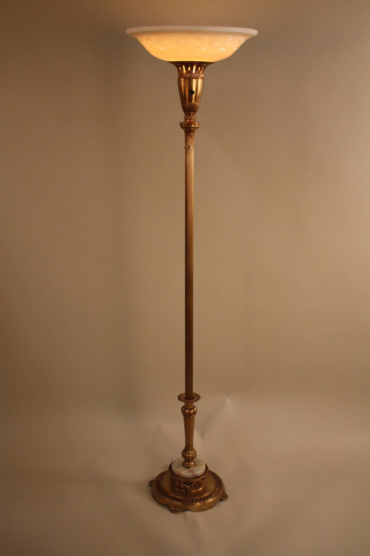 Elegant American Art Deco torchiere floor lamp with beautiful gold color and original glass shade.