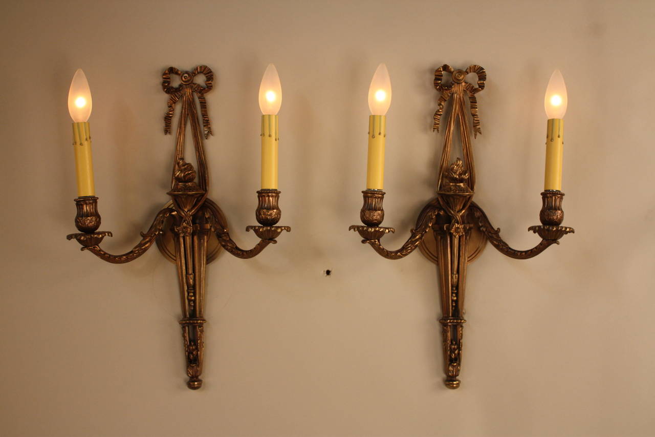 A fantastic pair of double-arm wall sconces. Made in France during the 1930s, the sconces feature solid bronze with great design.
