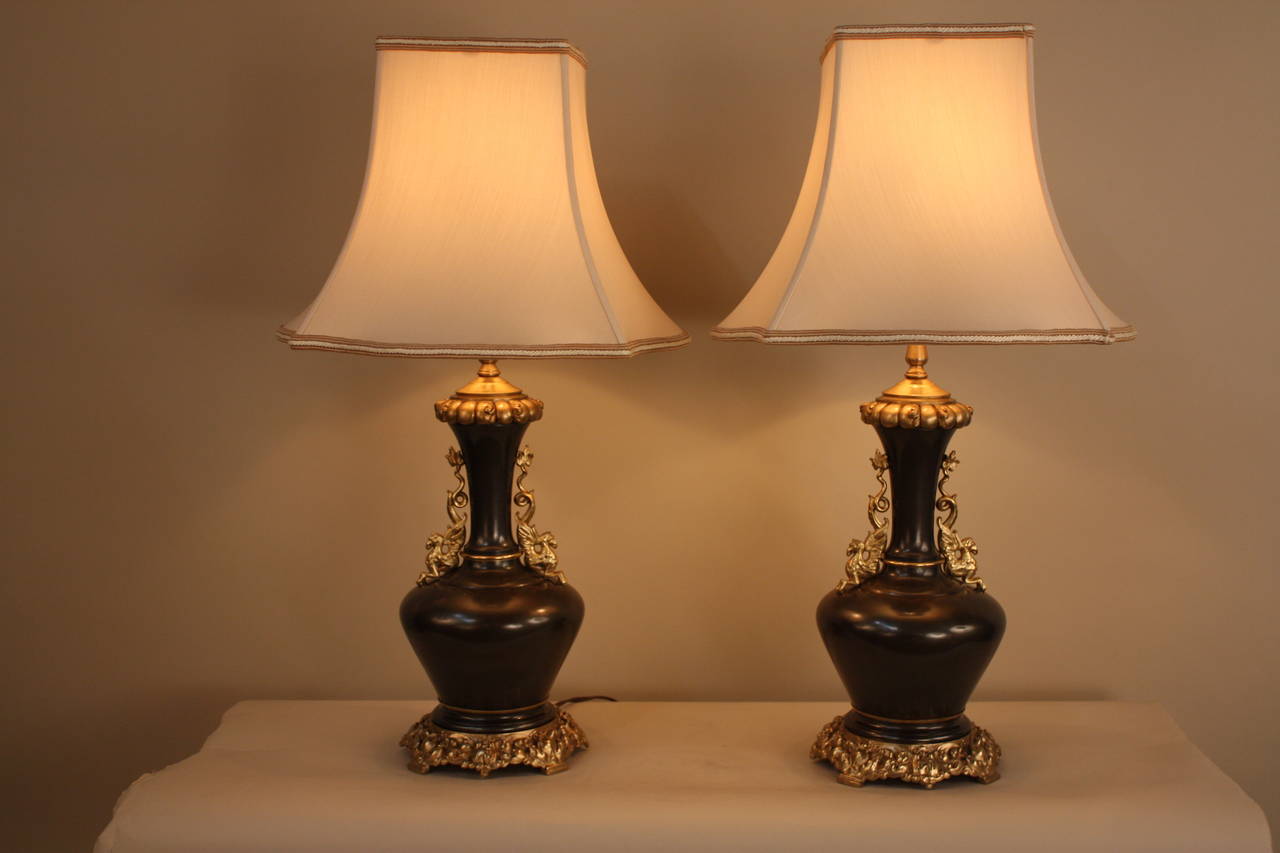 A beautiful pair of 19th century two-color bronze table lamps. Originally oil lamp that have been electrified. These lamps has been decorated, with ornate bronze hardware.