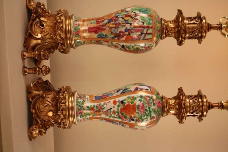 This beautiful pair of rose medallion porcelain vases has been electrified and custom converted to table lamps. 

The amount of precise detail work is absolutely stunning. From the elaborate bronze mounting, to the painted court scenes on the