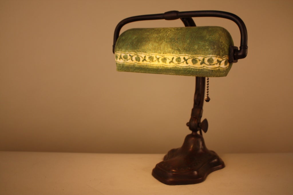 BEAUTIFUL HANDEL DESK LAMP ,BRONZED METAL BASE WITH ADJUSTABLE ARM AND ORIGINAL PATINA SUPPORTING A PAINTED GREEN SHADE WITH LEAF DESIGN.