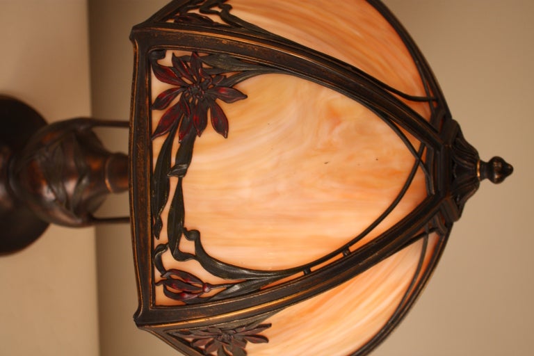A very beautiful American Art Nouveau table lamp. Six panels of stunning stained glass are the focal point of this wonderfully detailed piece.