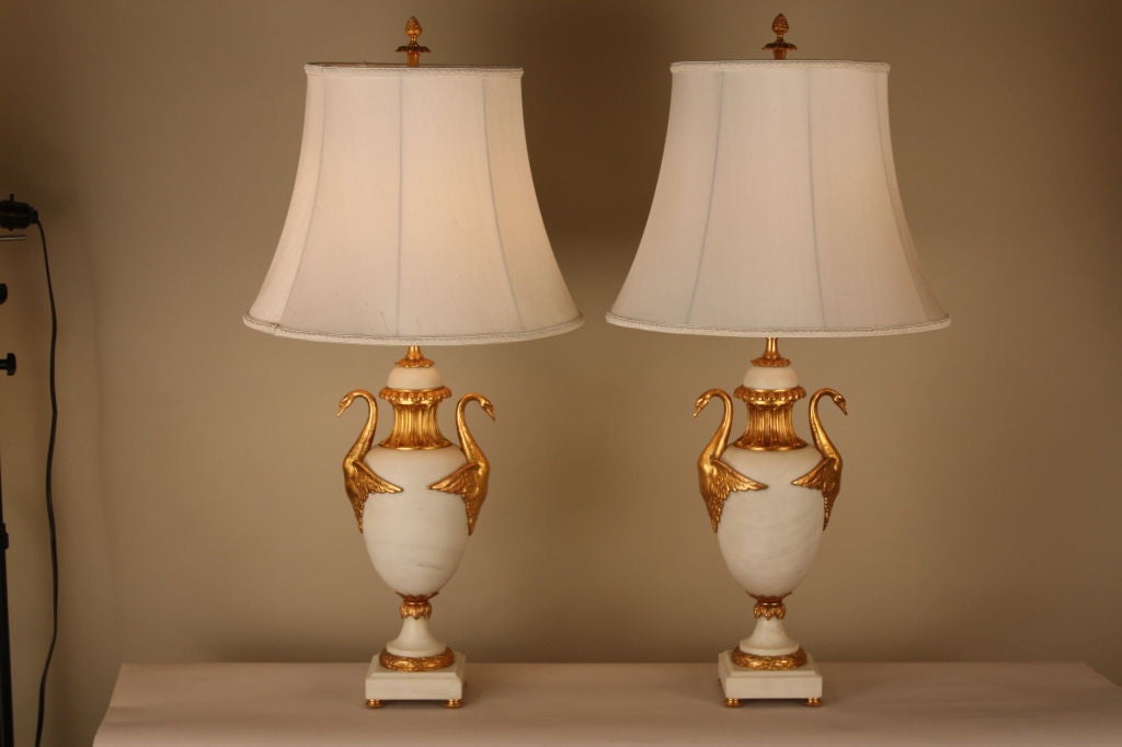This pair of urn lamps are crafted from white satin marble with gilded bronze handles in the shape of swans. A great example of exquisite workmanship.