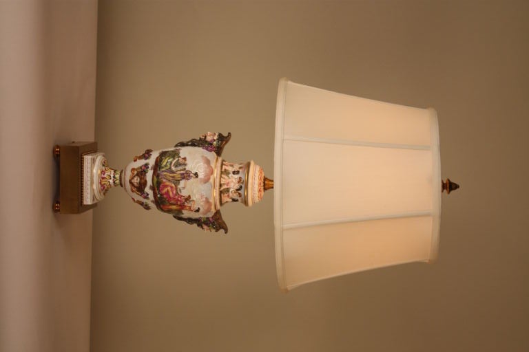 This hand painted capo-de-monte lamp is constructed from a beautifully decorated vase mounted on a brass base.