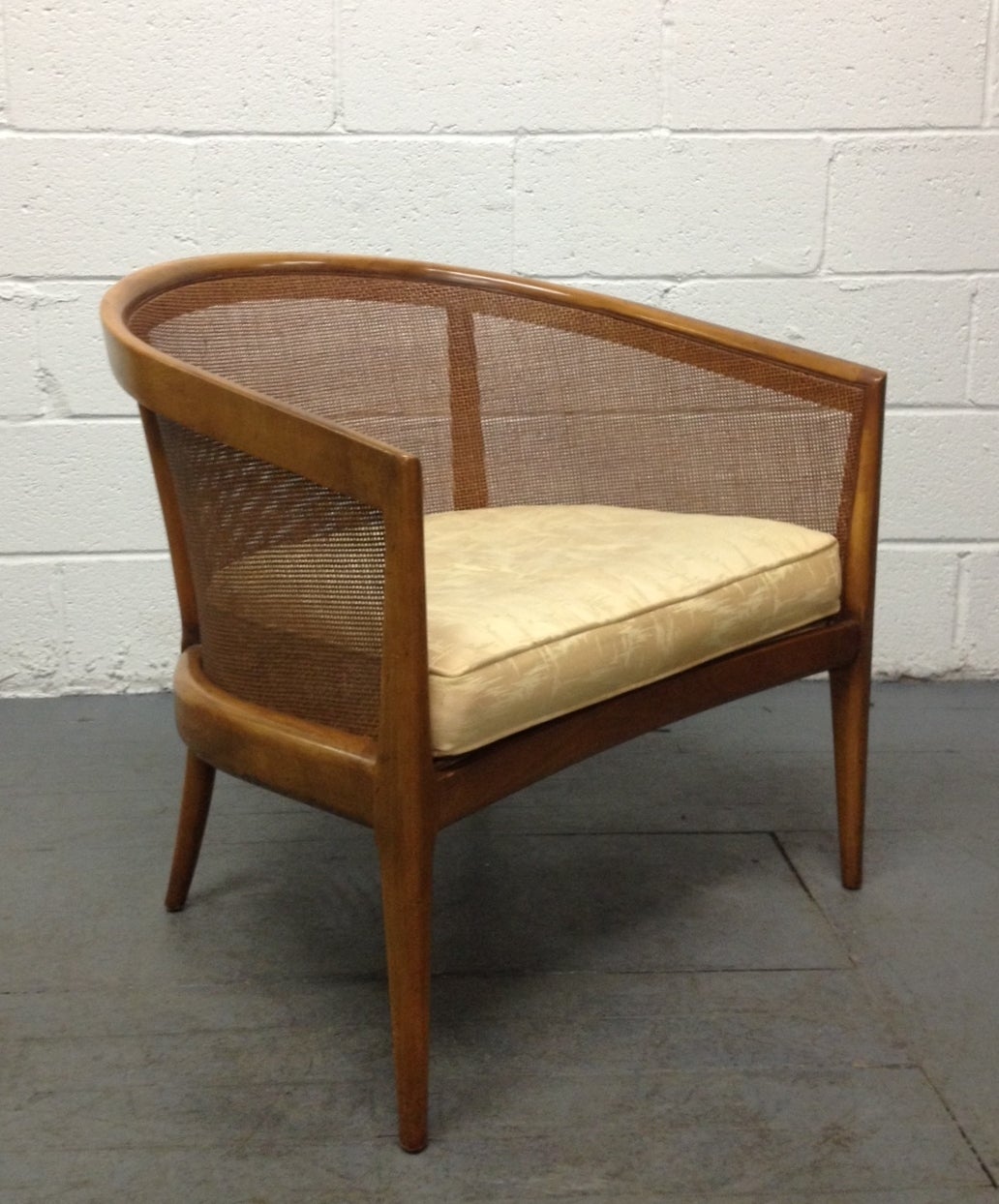 Pair of Kipp Stewart walnut lounge chairs with cane back and sides. Loose cushioned seats. Well designed.


