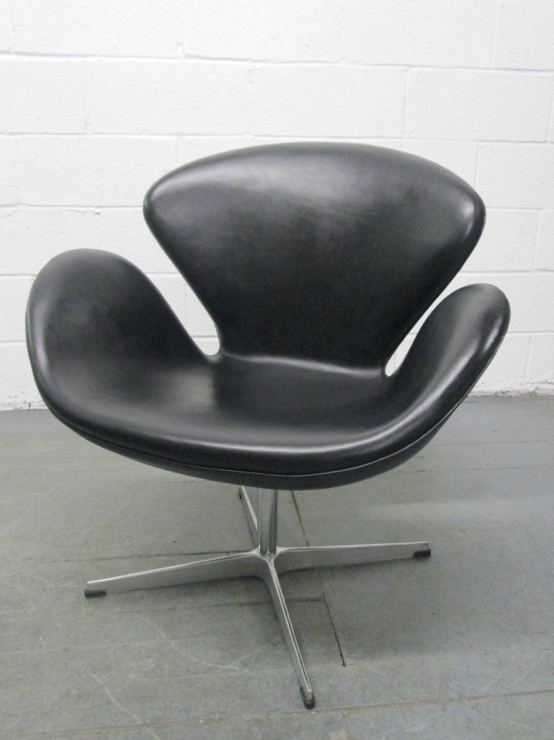 Swan Chair by Arne Jacobsen for Fritz Hansen.  Black leather, four-star base and the chair swivels.