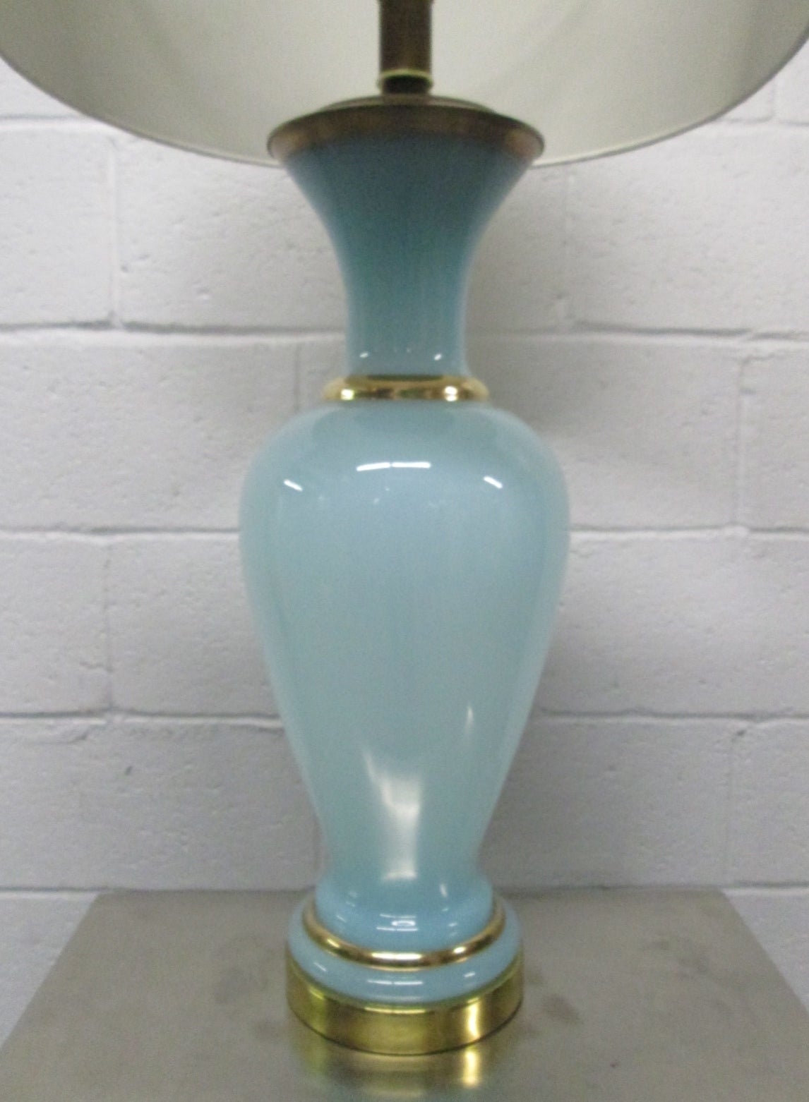 Pair of opaline lamps in teal with a brass base and brass top with gilded trim. Hollywood Regency.
Measures: 34.5H (to top of finial). 24.25H (to under bulb socket), and 7 in diameter at its widest. 
