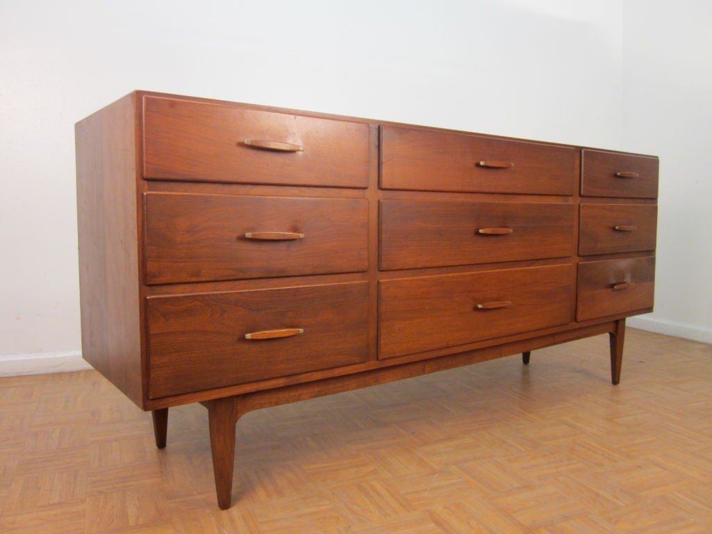 Beautiful mid century walnut 9 drawer dresser with lovely sculpted handles with metal tips.  Can also be used as a credenza.