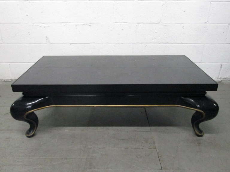 Asian slate top coffee table in the manner of James Mont. Black lacquered and gold base with a slate top.
