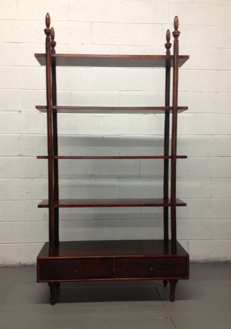Pair of rosewood étagères. Two pull-out drawers and brass knobs. Shelves are non-adjustable.