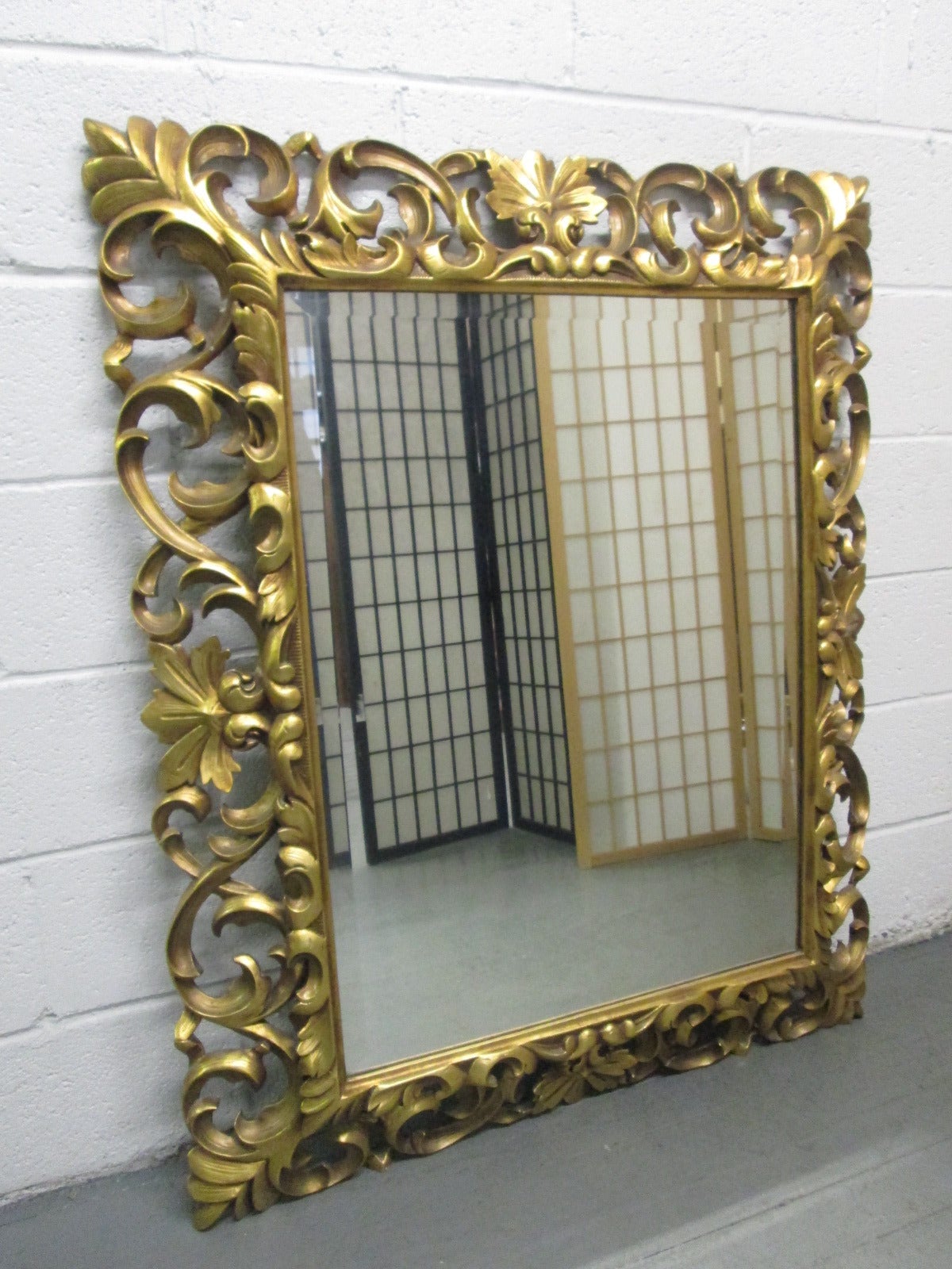 Decorative carved wooden gilt mirror. Mirror is beveled.