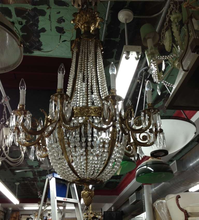 Large French bronze and crystal chandelier. Chandelier has ten lights on the outside and seven lights inside. Has an acorn at the bottom and crystal beading throughout. The bronze has been polished. Originally candle powered and has been