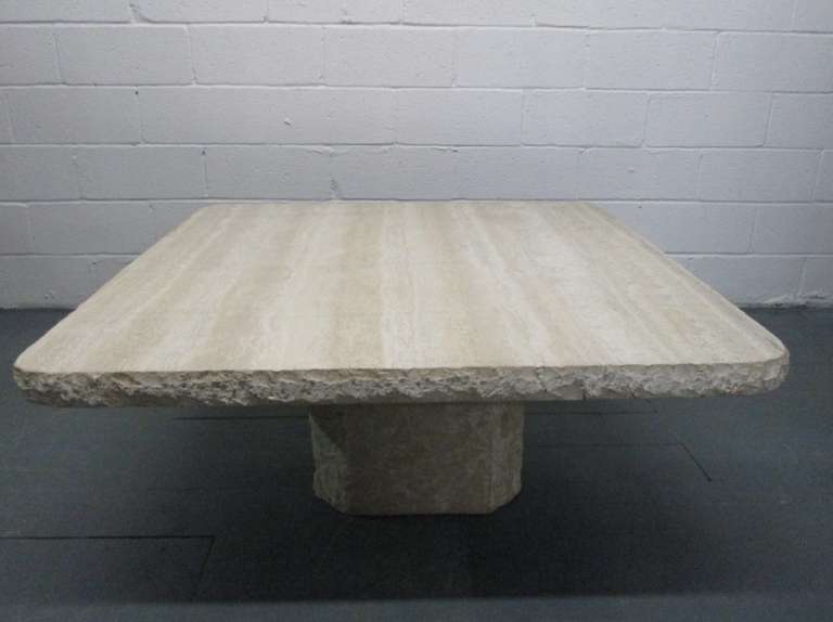 Italian Travertine Coffee Table in two parts.  The base and side edges of the top has a rough feel.  The solid top has a polished finish.  Top is not attached to base.  Base is hollow.