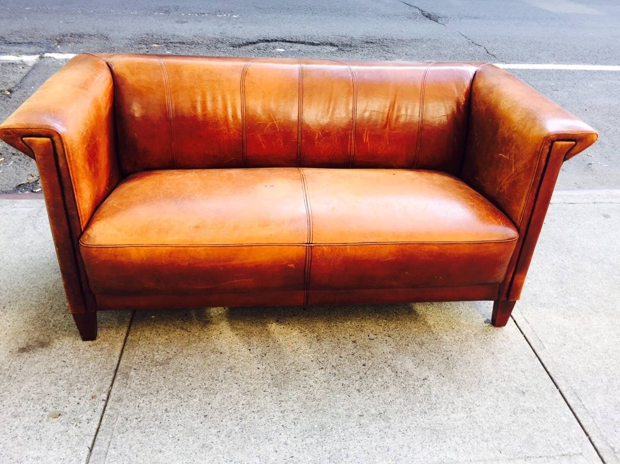 Vintage Italian distressed leather loveseat/sofa. Has nice wear to the leather and really nice lines. Sofa has wood legs.