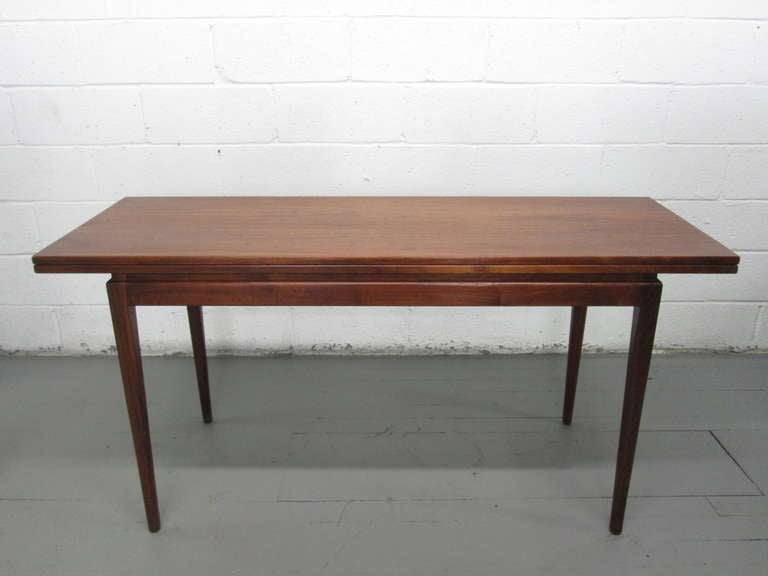 Jens Risom walnut dining table which also can be used as a console table. Perfect size for a desk or can actually be used as a game table as well. Has a really beautiful walnut grain. Top fully open measures: 21