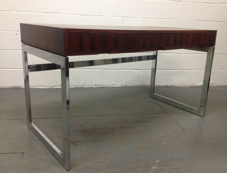 Milo Baughman style rosewood and chrome desk. Desk has three hidden drawers and a beautiful cubed chrome steel base. Nice lines.