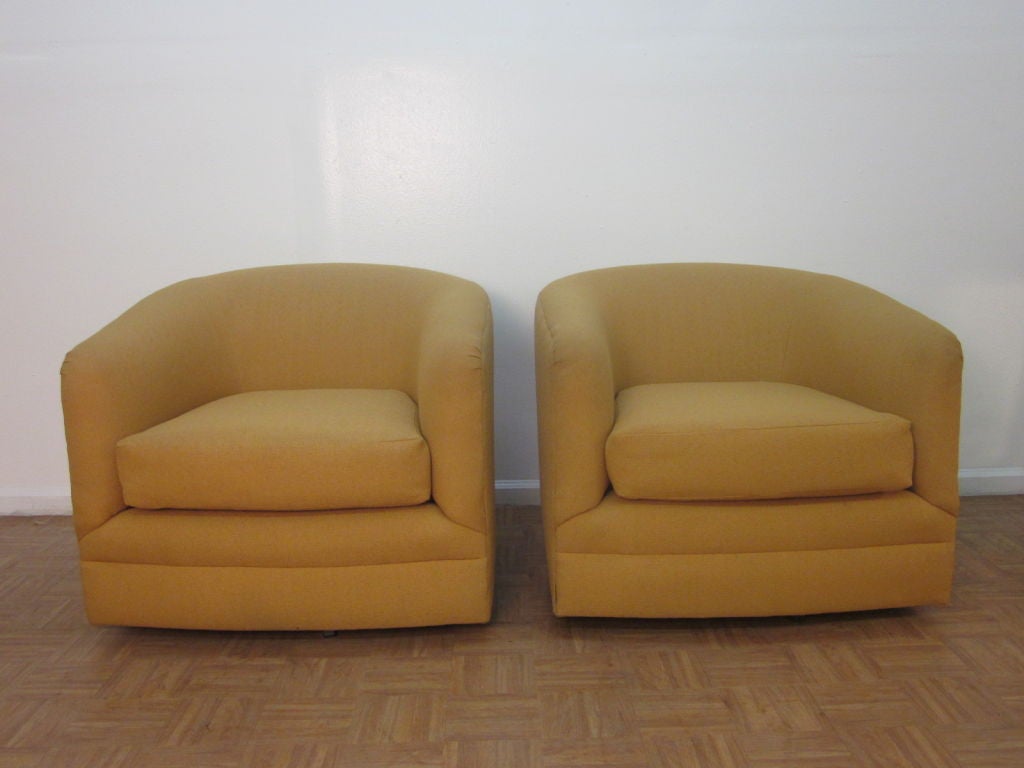 Pair of upholstered barrel back swivel chairs.