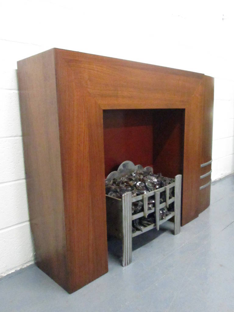 Spectacular Art Deco fireplace and mantel. Well made. The fireplace and mantel has one curved side with metal detail toward the bottom.

The grill shown is not available.